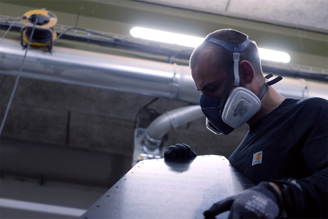 Sebastian inspecting one of the first freshly cut carbon fiber panels.